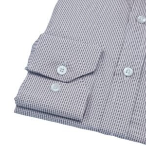 Close do punho com botões da camisa social quadriculado branco e bordo em fundo branco.