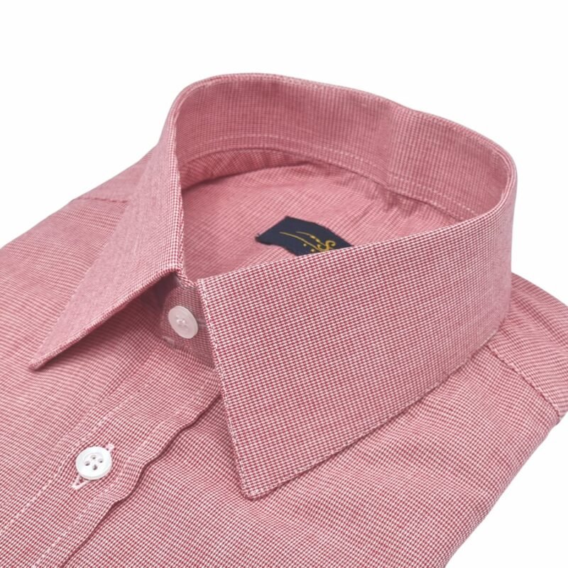 Camisa social vermelha com estampa discreta em algodão 100%, vista diagonal destacando o colarinho estruturado e o acabamento da peça.