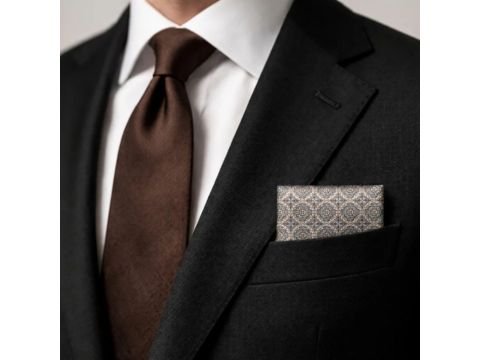 Detalhe de terno preto com camisa branca, gravata marrom e lenço de bolso arabesco marrom e bege MS Stilos dobrado no bolso do paletó