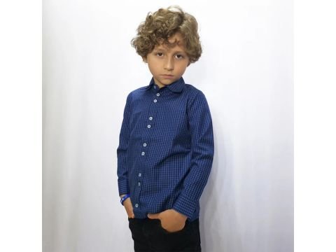 Menino em pé usando camisa social infantil azul xadrez, mãos nos bolsos, look elegante para festas e eventos especiais