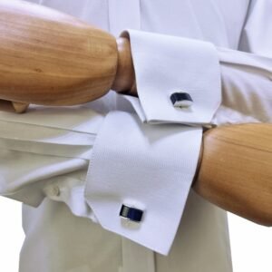 Close-up dos punhos duplos com abotoaduras pretas em camisa branca sulfite no manequim de madeira - MS Stilos.