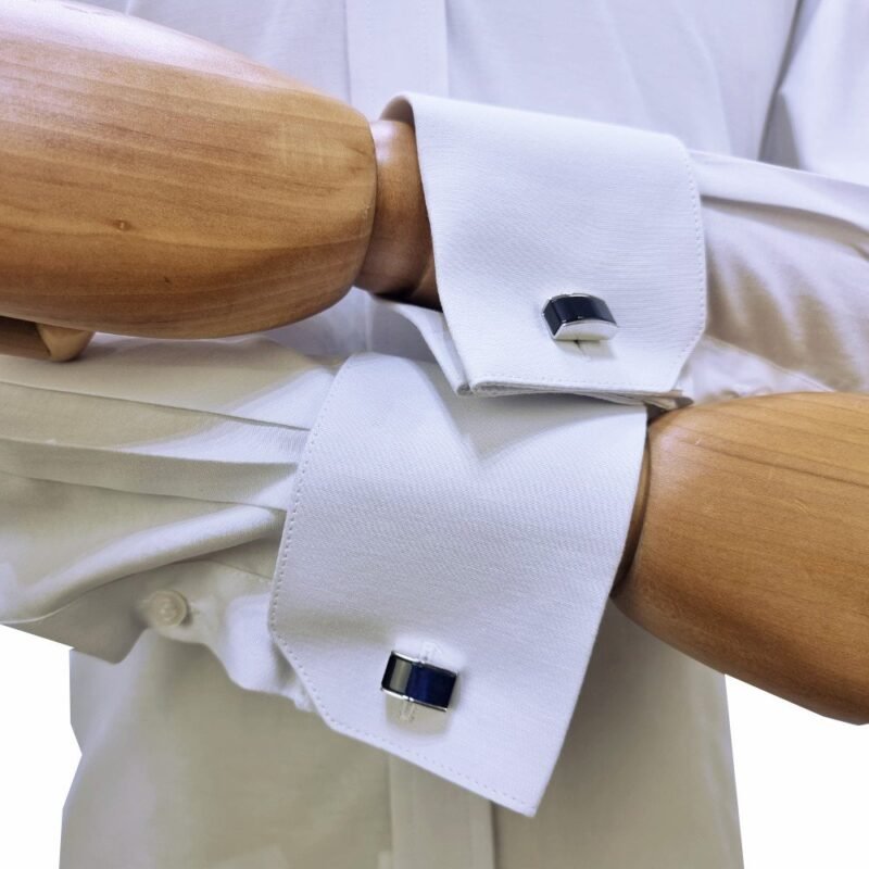 Close-up dos punhos duplos com abotoaduras pretas em camisa branca sulfite no manequim de madeira - MS Stilos.