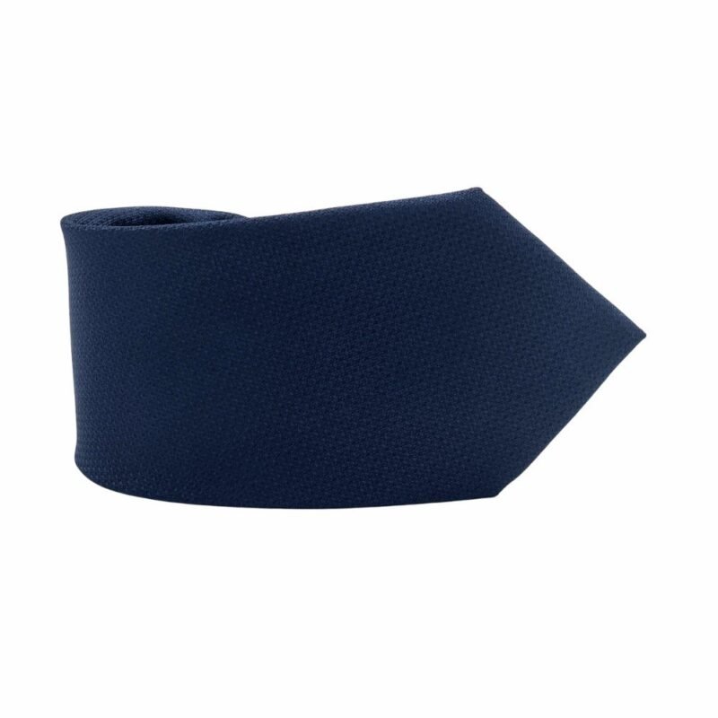 Detalhe da ponta larga da gravata azul escuro lisa tradicional