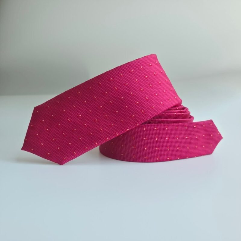 Gravata slim fit fucsia texturizada com microdetalhes enrolada destacando o caimento e a textura do tecido