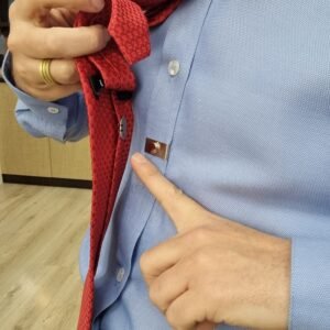 Detalhe aproximado da base magnetica do ima fixada no tecido da camisa social azul