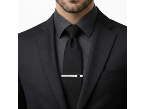 Prendedor de gravata prata com detalhe preto da MS Stilos aplicado em gravata preta com terno escuro.