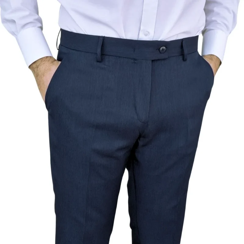 Calça social azul noite estampa lisa vestida, mãos nos bolsos frontais