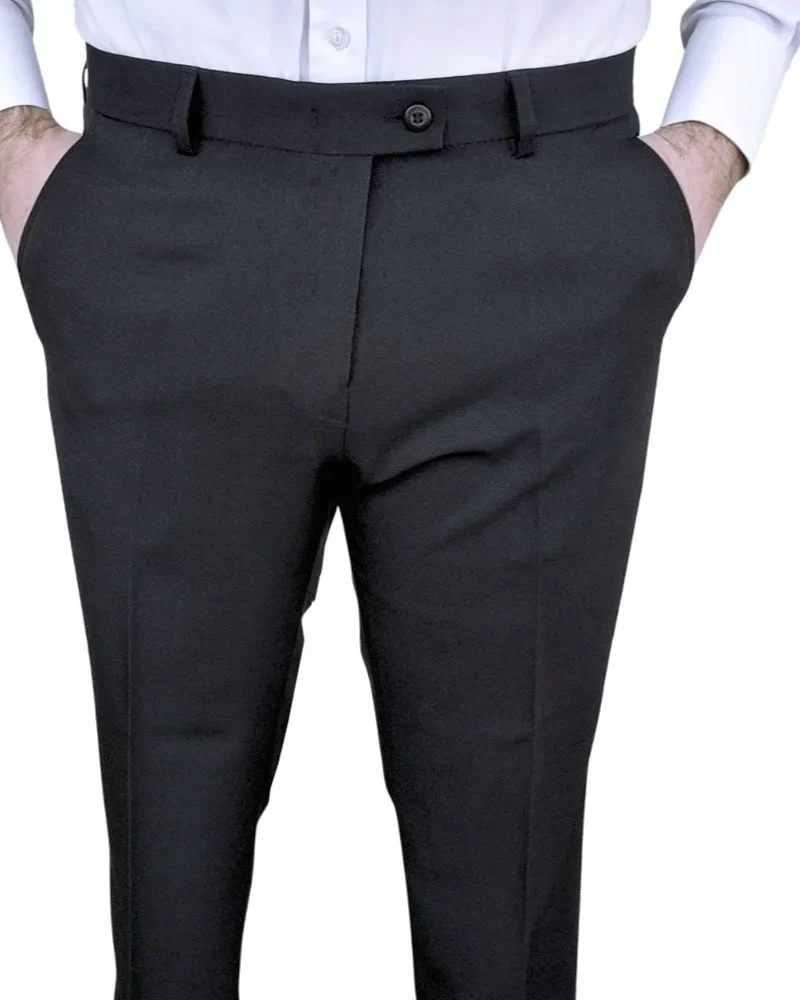 Calça social preta lisa com elastano, vista frontal com mãos nos bolsos