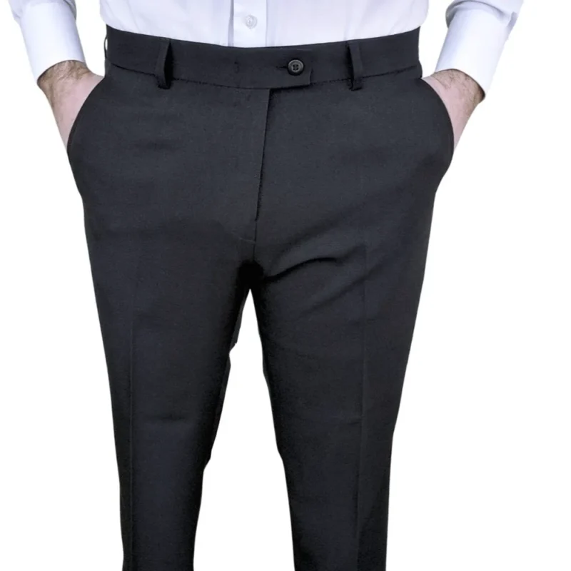 Calça social preta lisa com elastano, vista frontal com mãos nos bolsos
