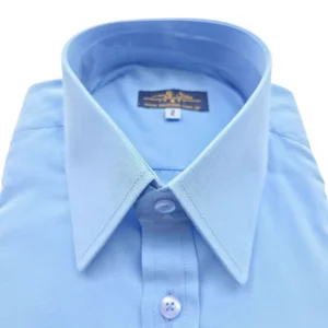 Close da gola inglesa da camisa azul lisa, com as pontas fechadas e pontudas
