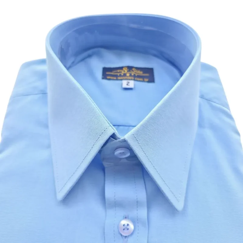 Close da gola inglesa da camisa azul lisa, com as pontas fechadas e pontudas