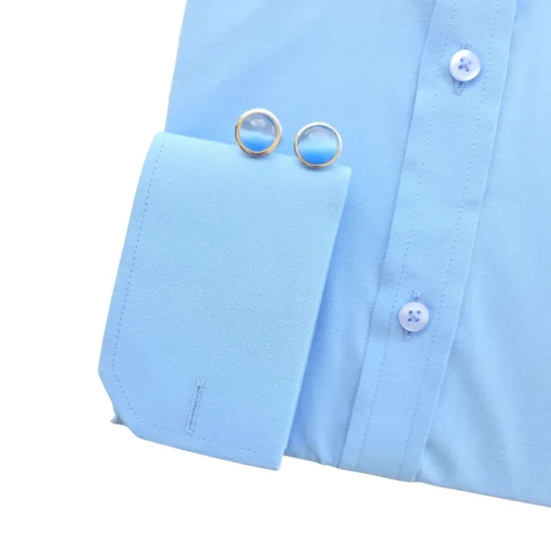 Punho duplo da camisa azul lisa, com a casa para abotoadura em destaque
