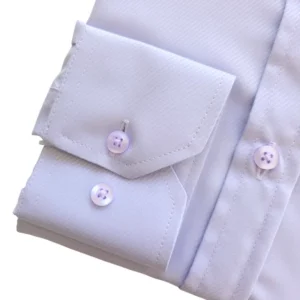 Detalhe do punho de botão da camisa lilás claro, com o tecido maquinetado