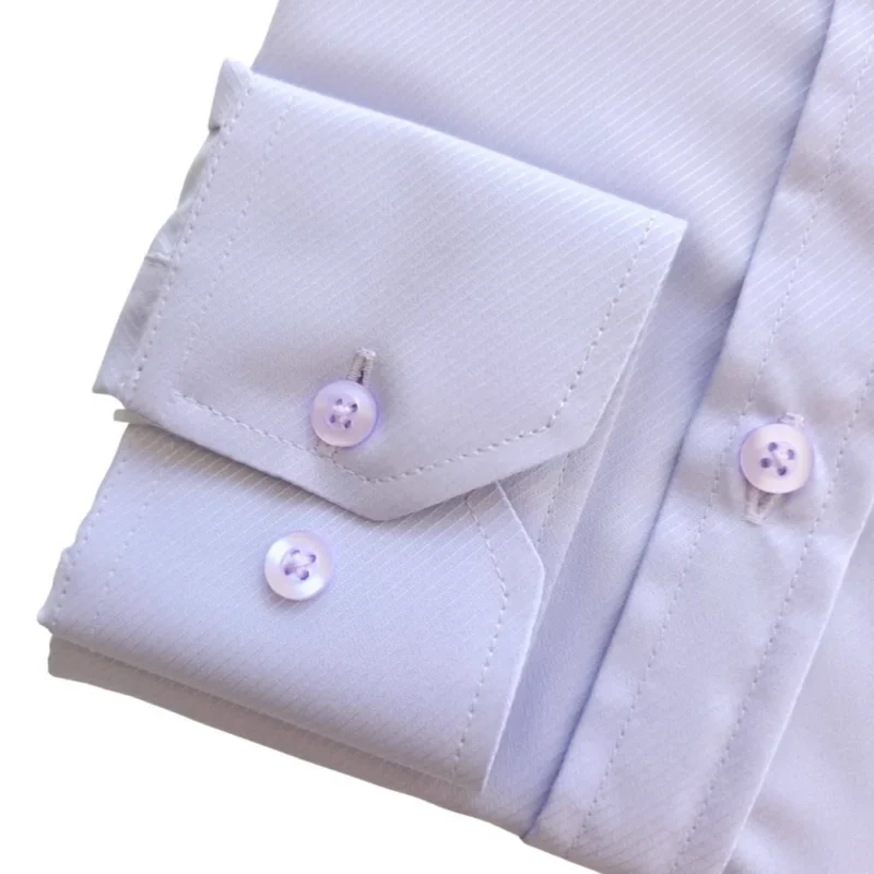 Detalhe do punho de botão da camisa lilás claro, com o tecido maquinetado