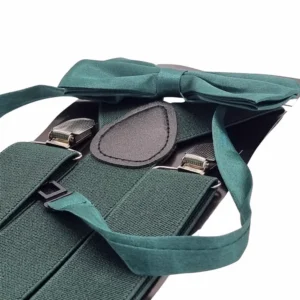 Detalhe da gravata borboleta verde sobre o suspensório, com as presilhas metálicas ao lado