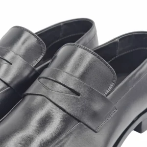 Detalhe da tira frontal vazada e da costura em couro do loafer social preto
