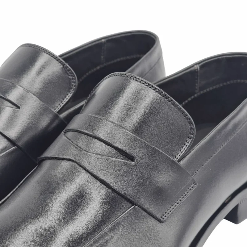 Detalhe da tira frontal vazada e da costura em couro do loafer social preto