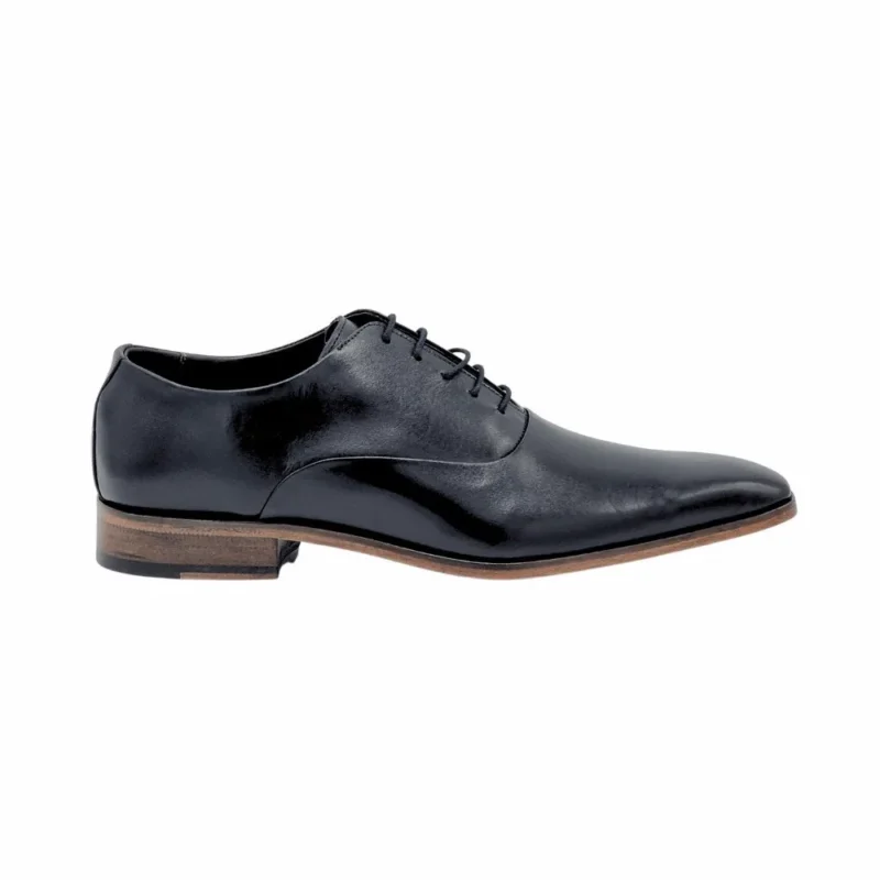 Perfil do sapato Oxford preto, com o salto e o solado em couro marrom