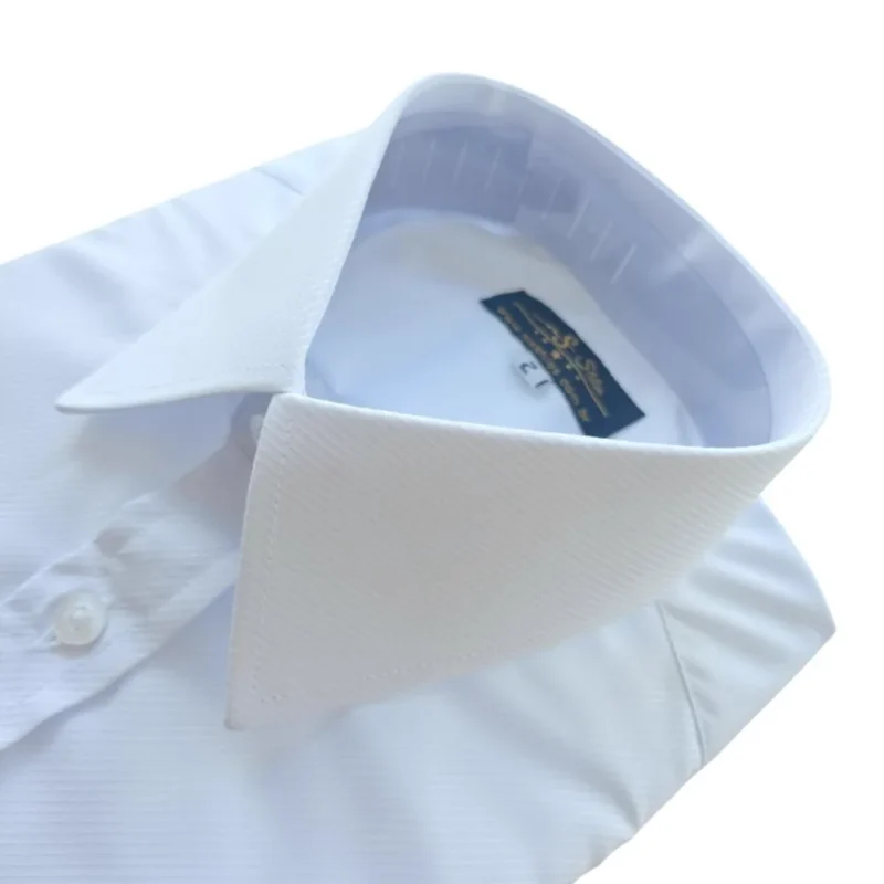 Colarinho francês visto de cima, com a textura maquinetada da camisa branca