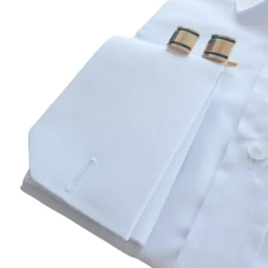 Punho duplo da camisa branca maquinetada com o par de abotoaduras douradas de faixa preta
