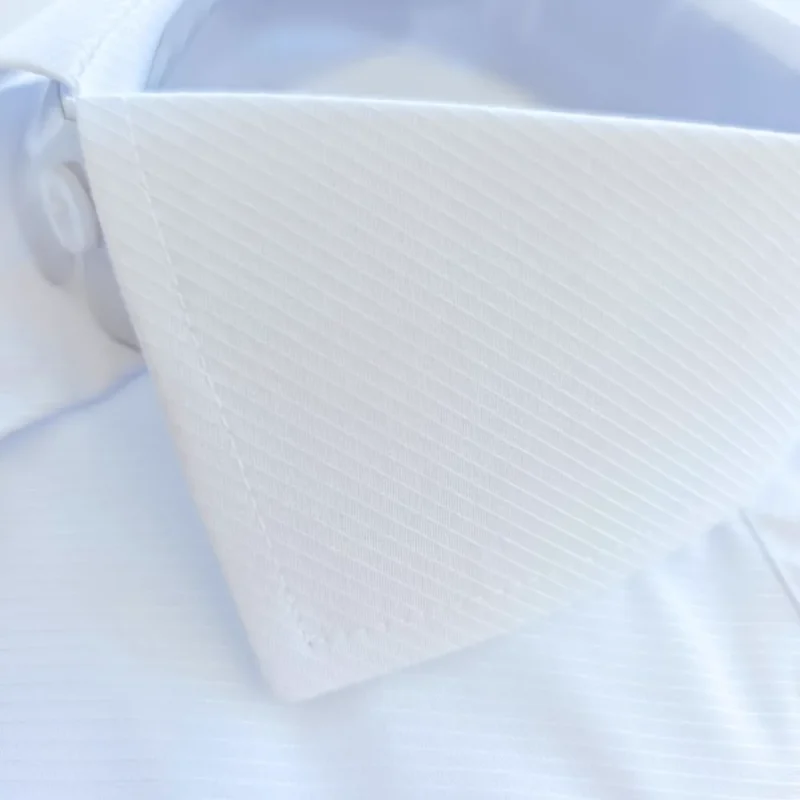 Textura maquinetada em linhas diagonais na ponta do colarinho italiano da camisa branca