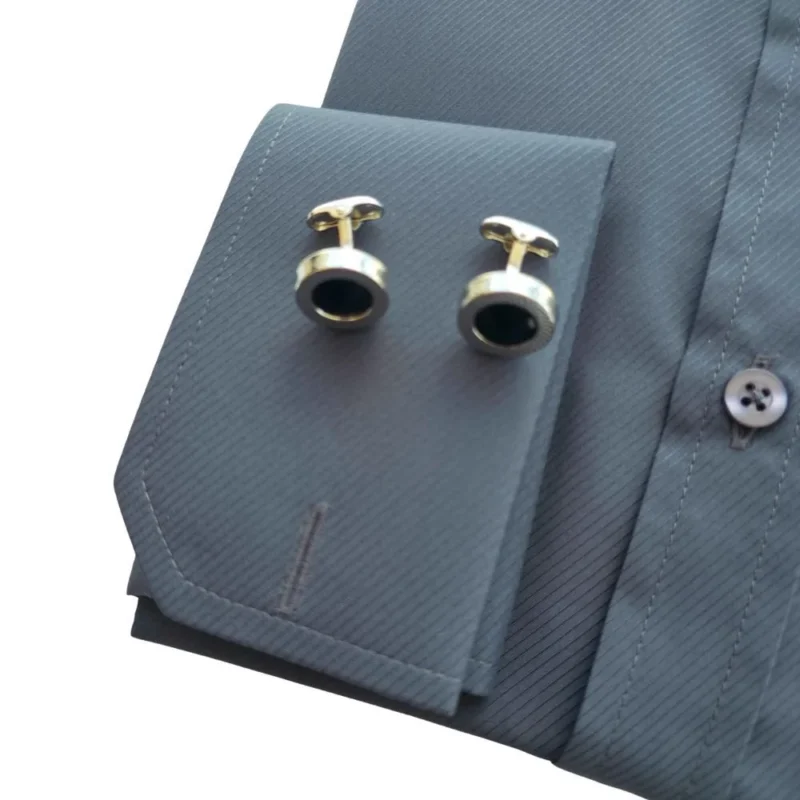 Punho duplo da camisa cinza chumbo com o par de abotoaduras redondas douradas de centro preto