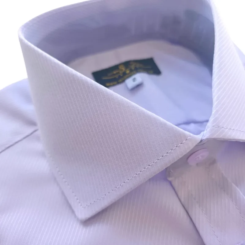 Colarinho italiano da camisa lilás claro, com a etiqueta MS Stilos e o botão da carcela